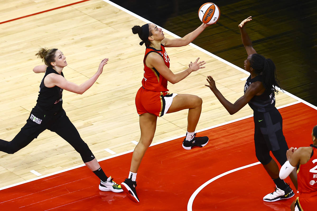 Las Vegas Aces' Dearica Hamby, center, drives to the basket between Seattle Storm's Katie Lou S ...
