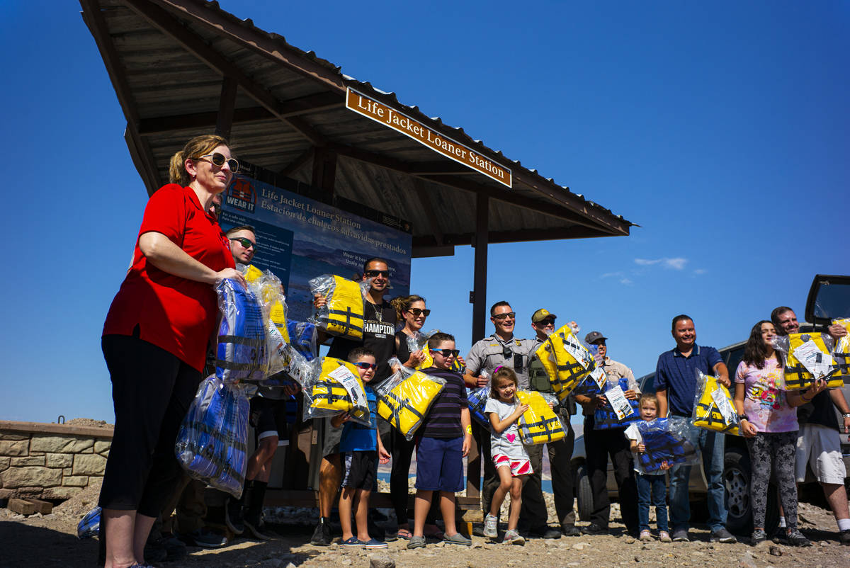 Lifejackets are delivered to park rangers as they pose for a picture at Boulder Beach at Lake M ...