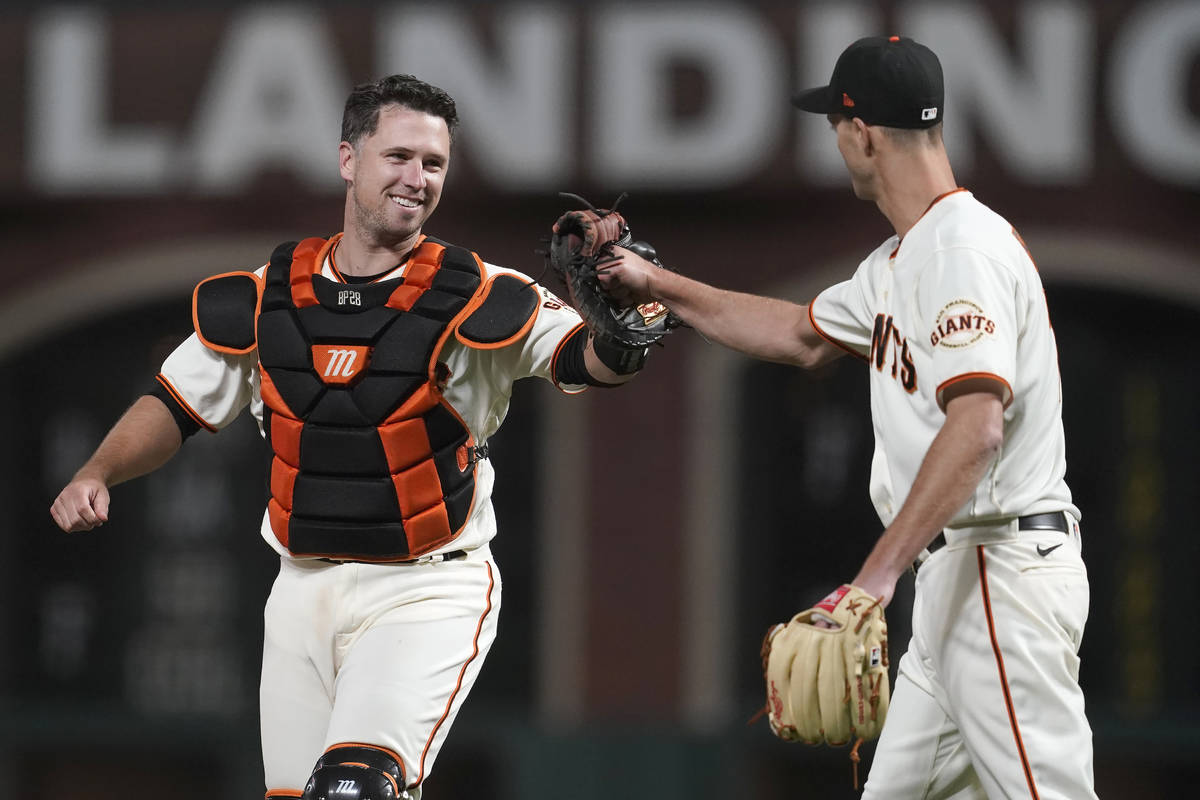San Francisco Giants catcher Buster Posey, left, celebrates with pitcher Tyler Rogers after the ...
