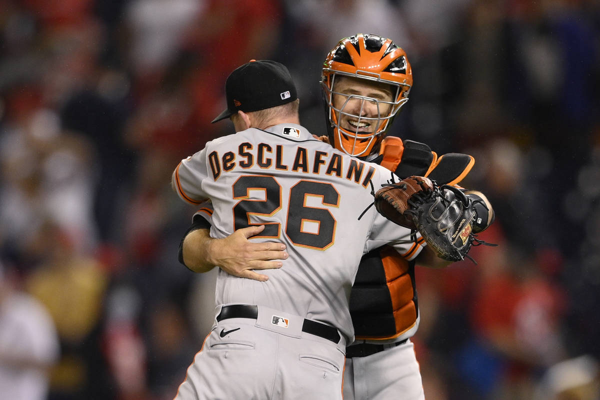 San Francisco Giants starting pitcher Anthony DeSclafani (26) and catcher Buster Posey, right, ...
