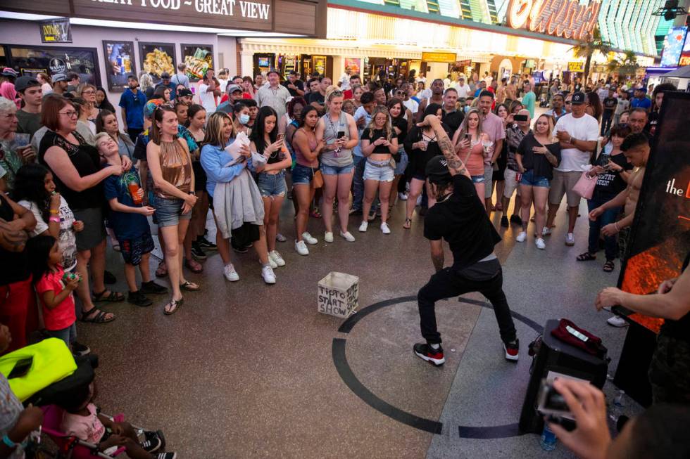 People watch a performer at the Fremont Street Experience in Las Vegas, Friday, July 2, 2021. ( ...