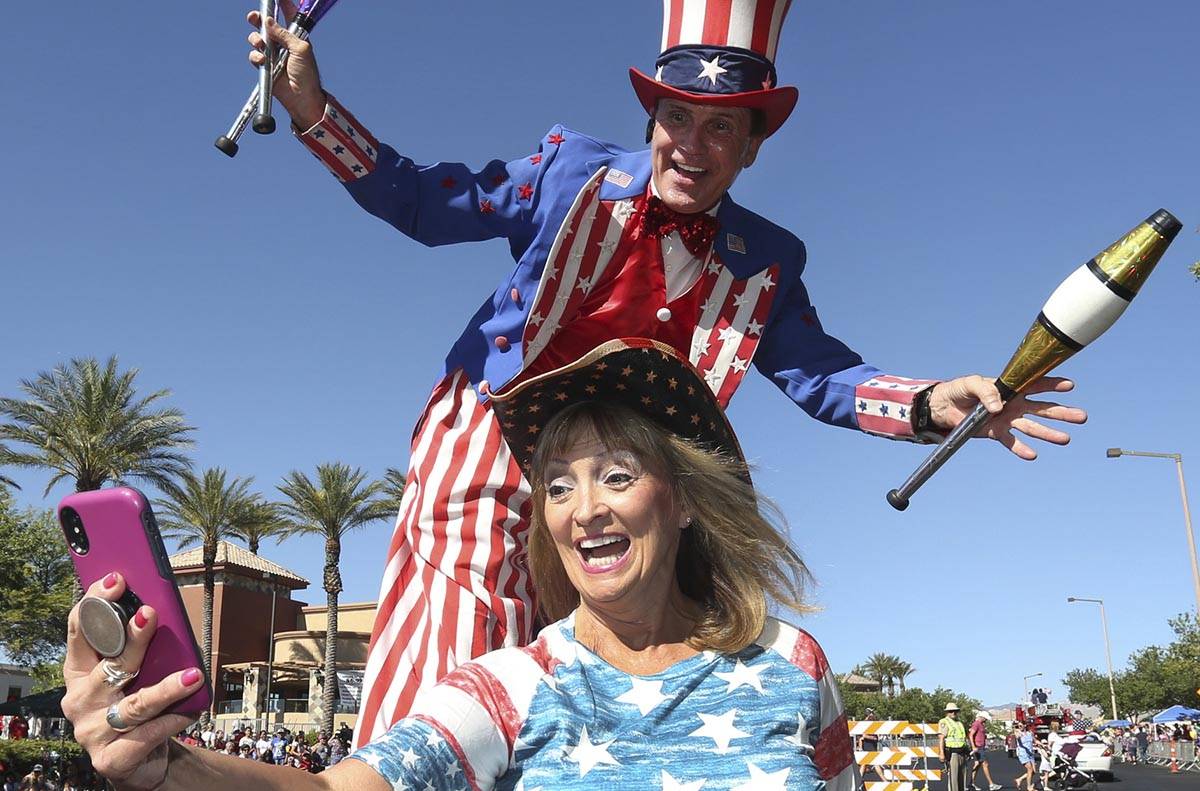 Kathy Koch takes a photo with a man dressed as Uncle Sam during the 25th annual Summerlin Counc ...