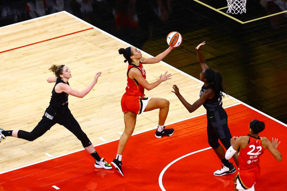 Las Vegas AcesÕ Dearica Hamby, center, drives to the basket between Seattle StormÕs K ...