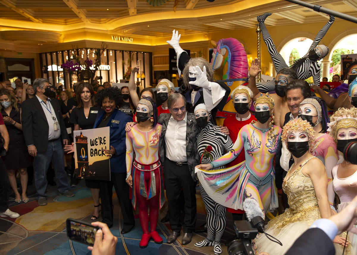 Cast members of "O," and Cirque du Soleil CEO Daniel Lamarre, center, pose for photos ...