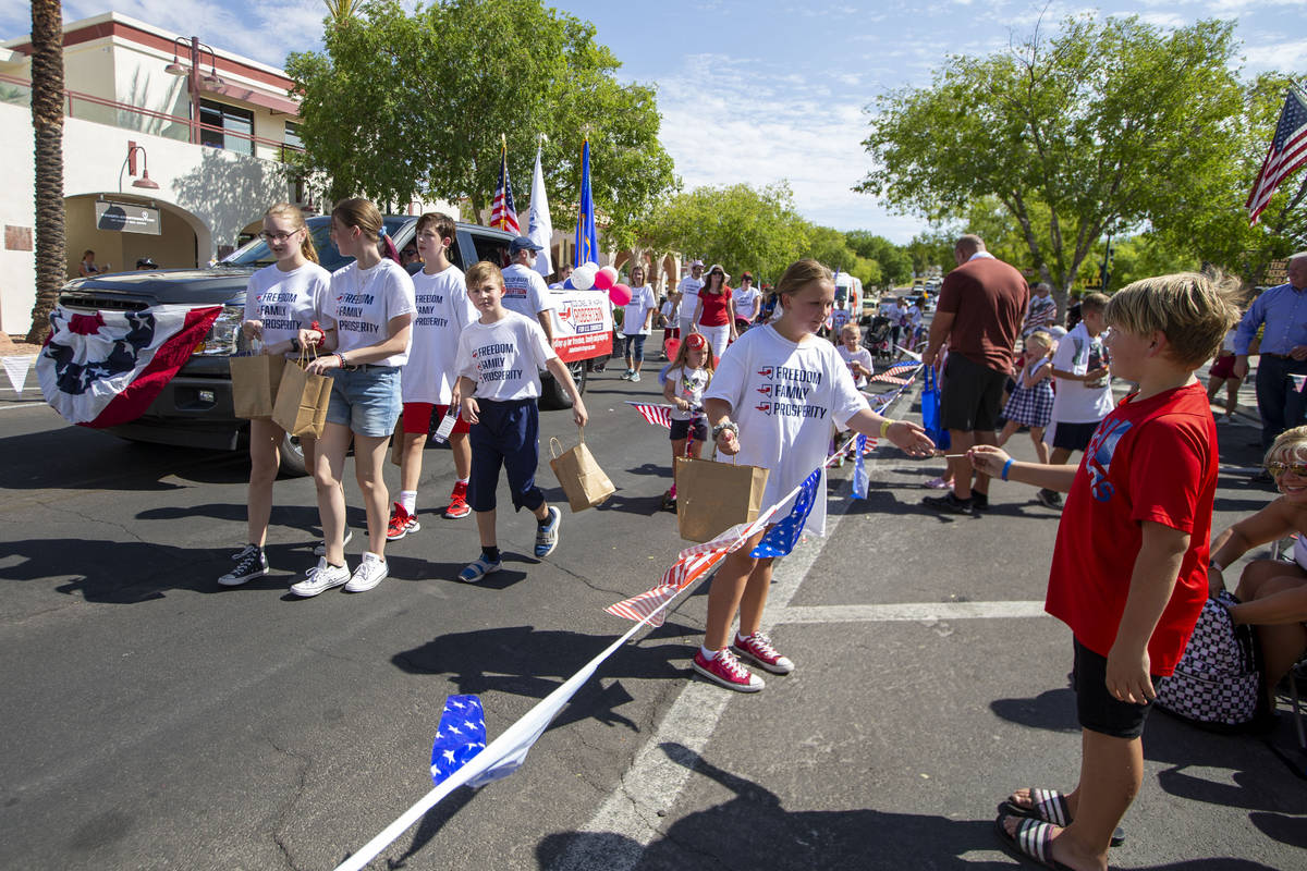 Parade marchers hand out candy to the crowd during the two-day Damboree event on Saturday, July ...
