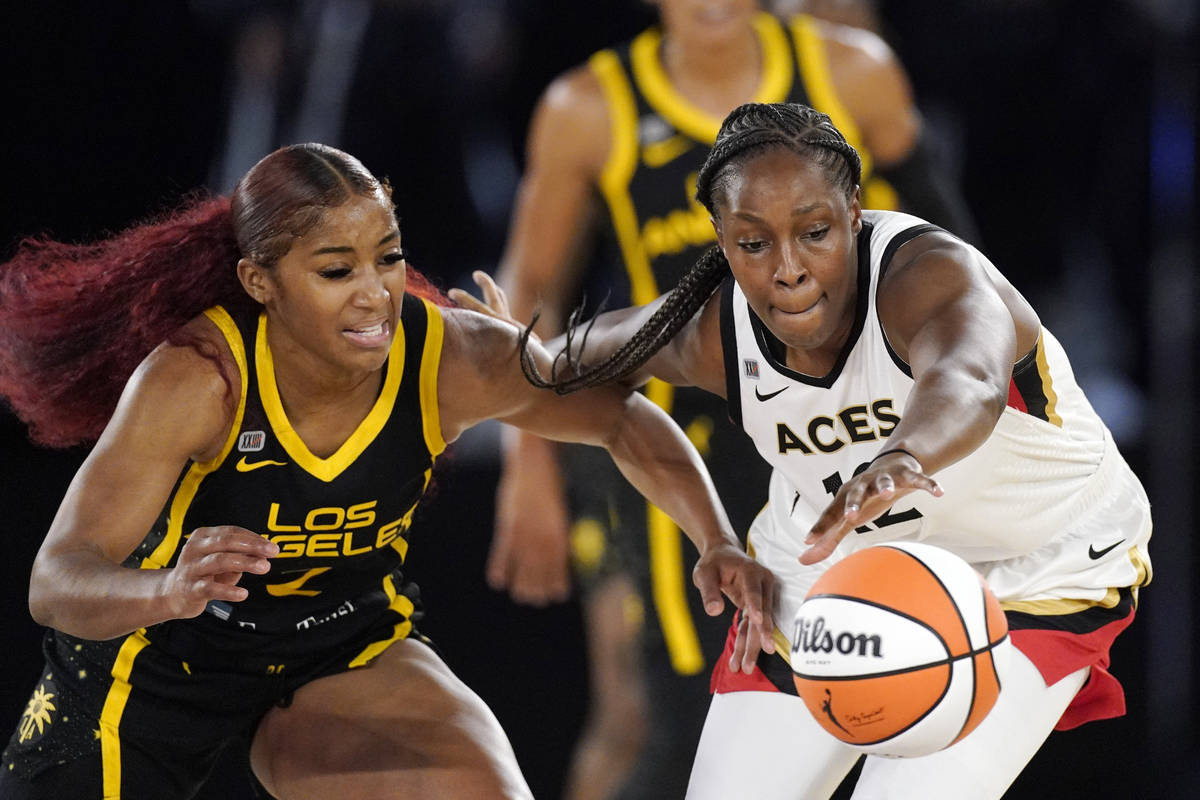Los Angeles Sparks guard Te'a Cooper, left, knocks the ball away from Las Vegas Aces guard Chel ...