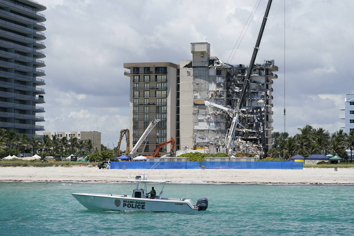 A Miami-Dade County Police boat patrols in front of the Champlain Towers South condo building, ...