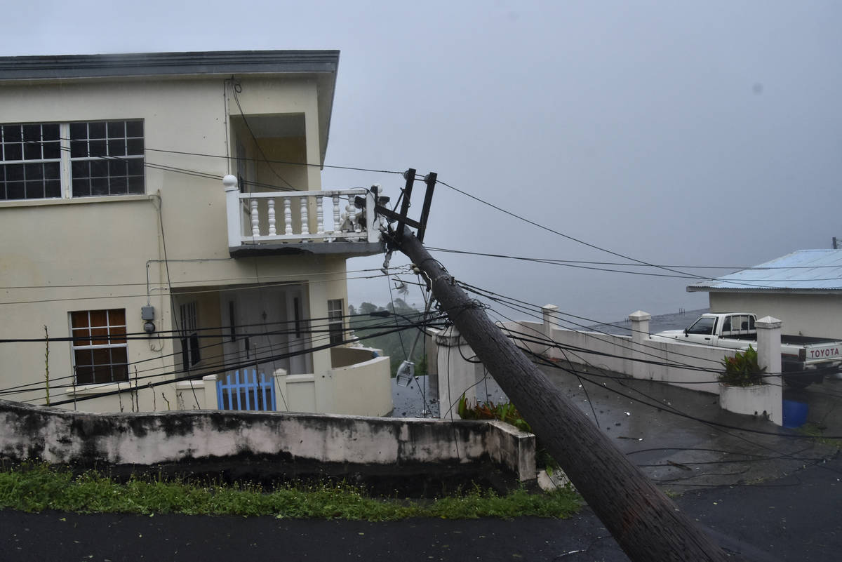 An electrical pole felled by Hurricane Elsa leans on the edge of a residential balcony, in Ceda ...
