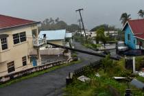 An electrical pole felled by Hurricane Elsa leans on the edge of a residential balcony, in Ceda ...