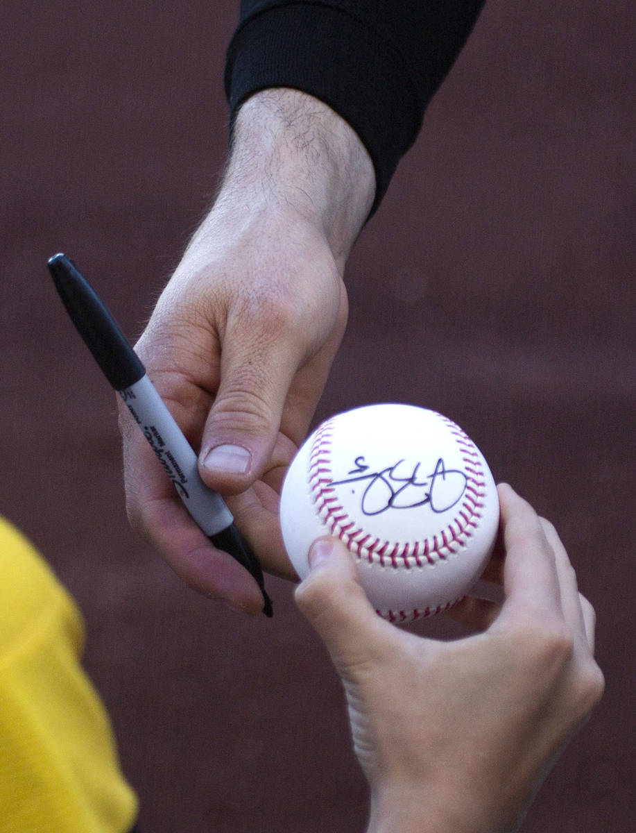 Sacramento River Cats outfielder Drew Robinson hands a signed ball to a young fan before a mino ...