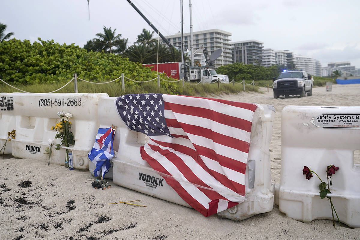 An American flag and fresh flowers are shown on a barricade just south of the collapsed Champla ...