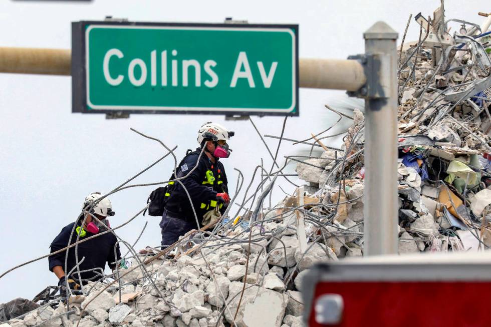 A search and rescue team members climb the rubble of the Champlain Towers South condo, Wednesda ...
