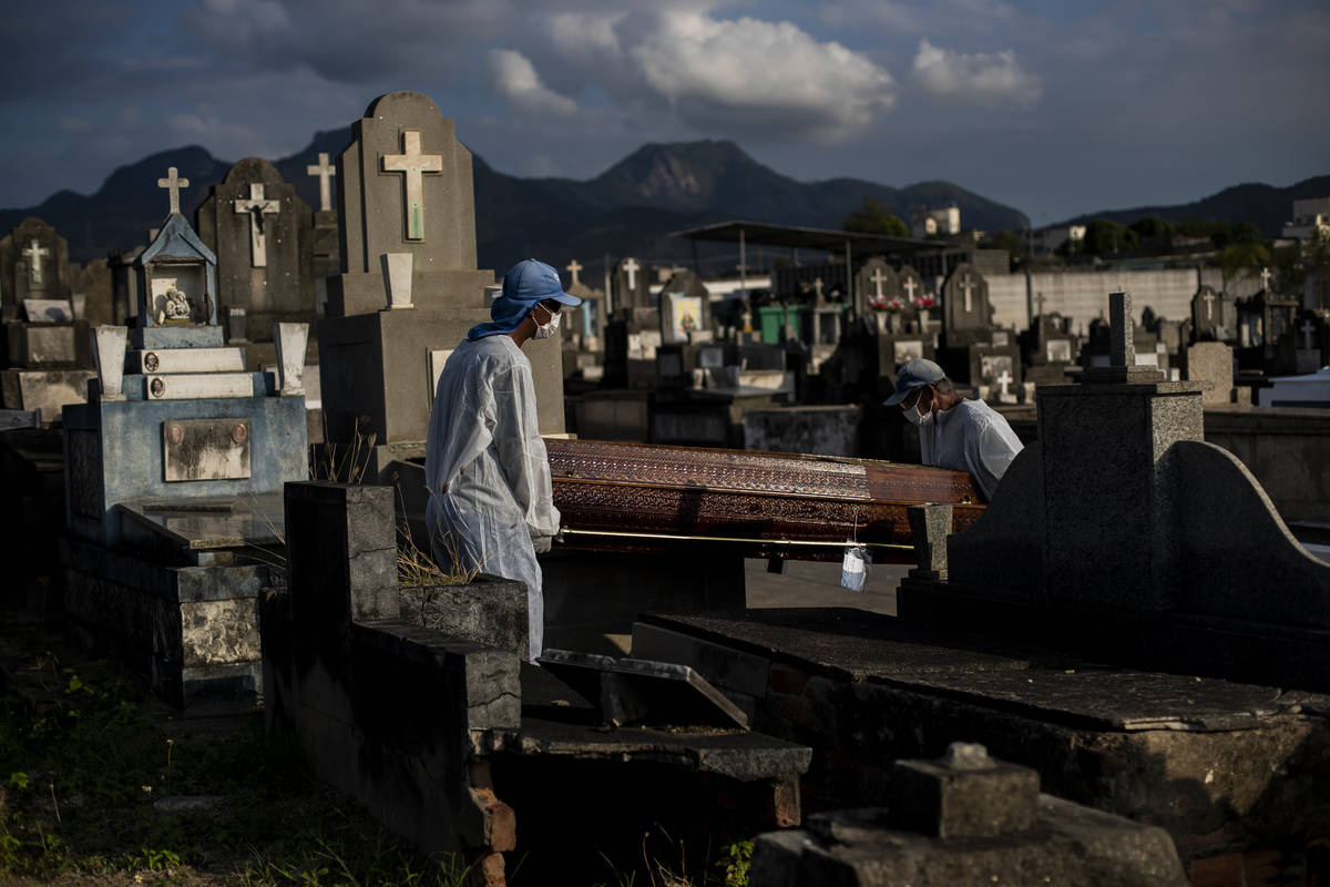 In this June 18, 2021, file photo, cemetery workers carry the coffin that contains the remains ...