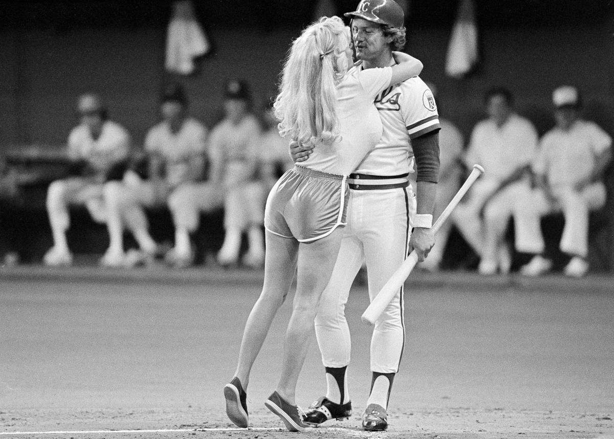 Kansas City Royals George Brett gets a hug and kiss from a woman in short-shorts during the All ...