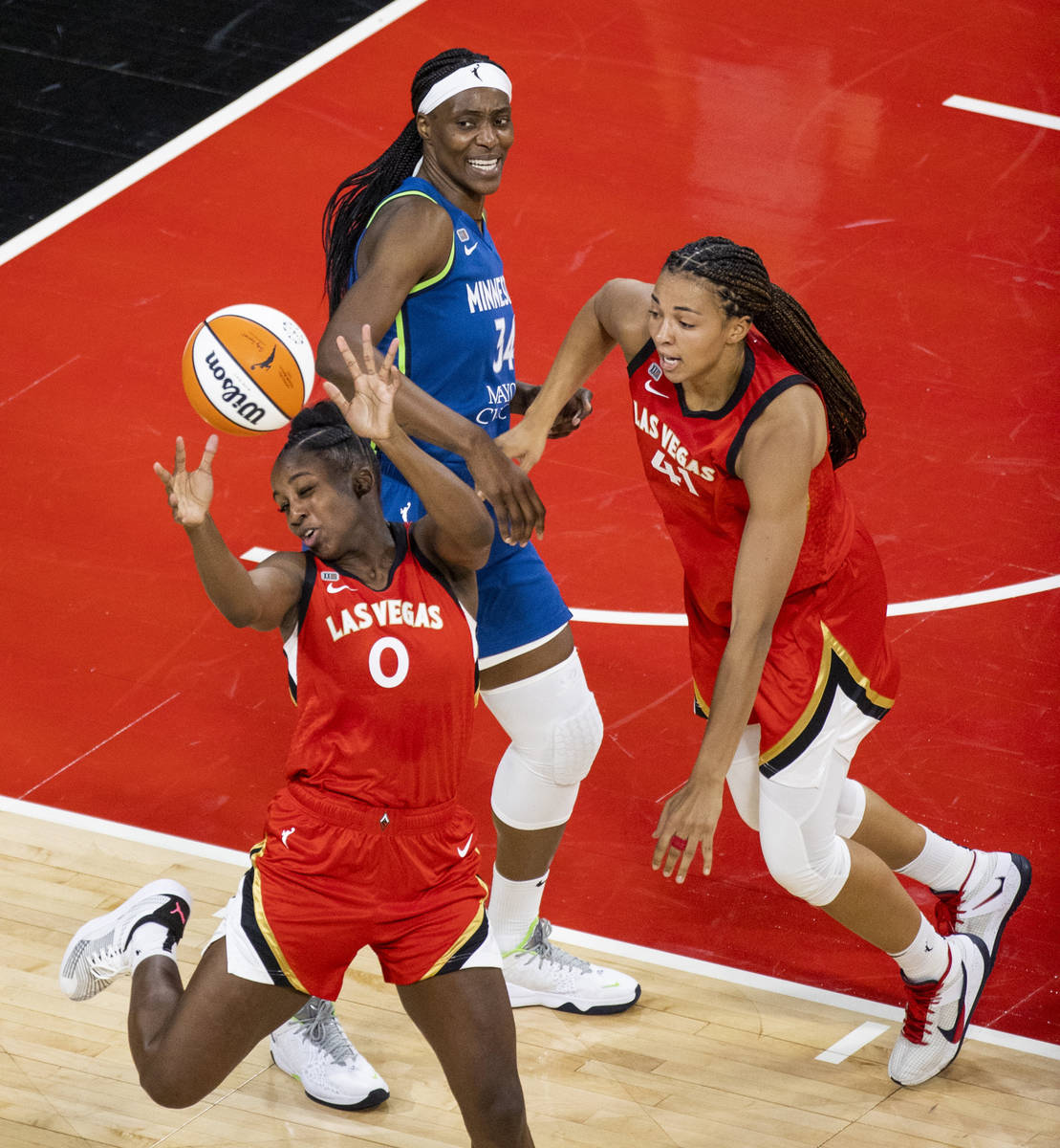 Las Vegas Aces guard Jackie Young (0) looks to secure a loose ball with teammate center Kiah St ...