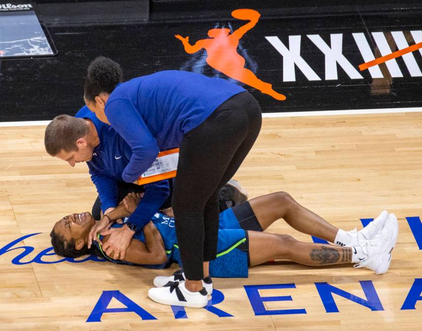 Minnesota Lynx guard Crystal Dangerfield (2) is attended to on the court after a shoulder injur ...