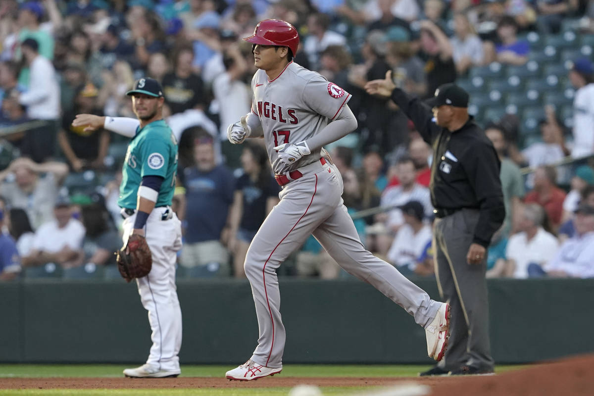Los Angeles Angels' Shohei Ohtani, center, rounds the bases as Seattle Mariners first baseman T ...