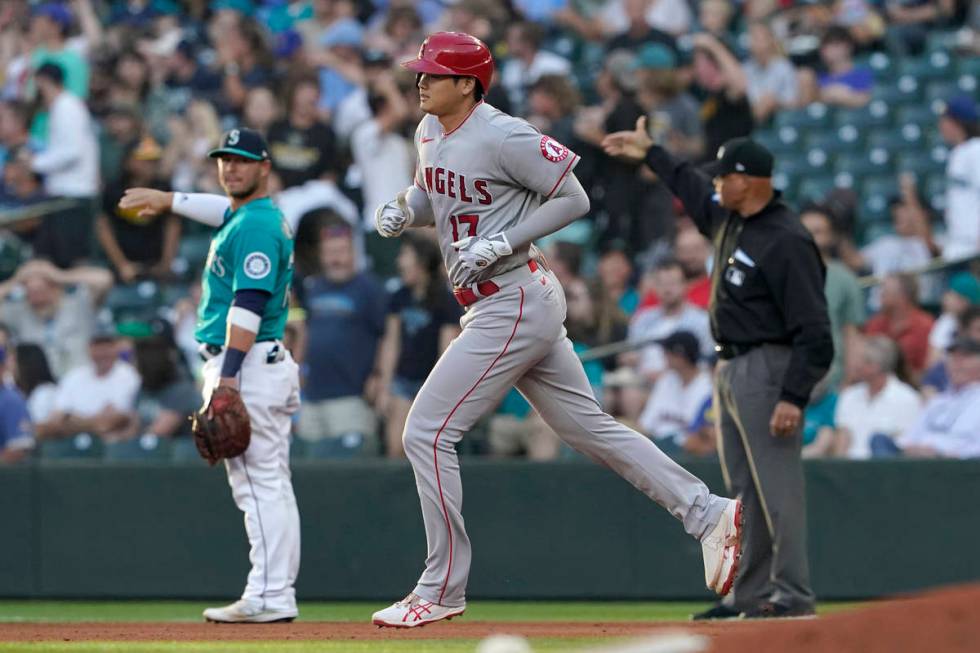 Los Angeles Angels' Shohei Ohtani, center, rounds the bases as Seattle Mariners first baseman T ...