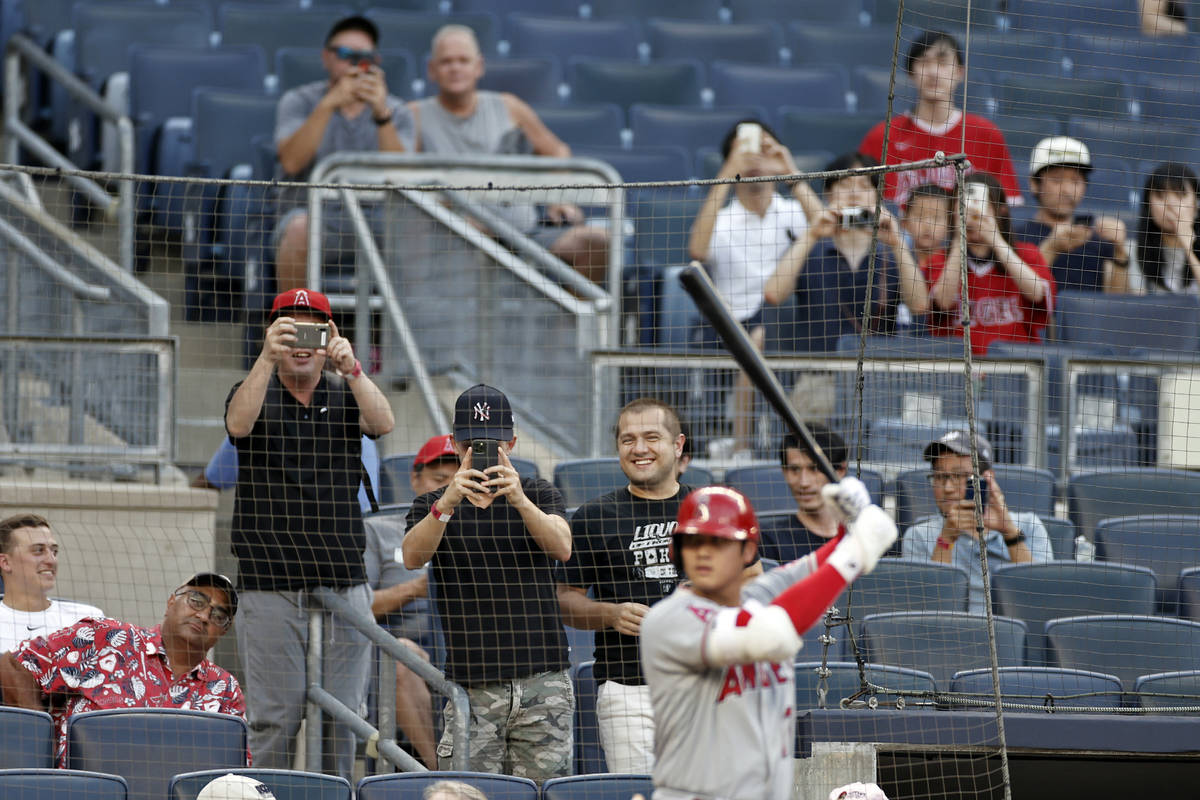 Fans take photos of Los Angeles Angels' Shohei Ohtani during the first inning of the team's bas ...