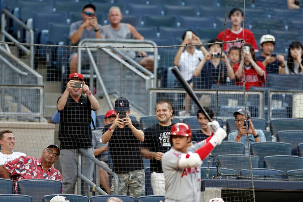 Fans take photos of Los Angeles Angels' Shohei Ohtani during the first inning of the team's bas ...