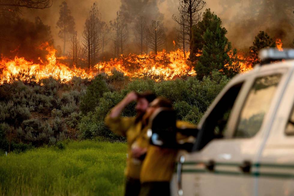 U.S. Forest Service firefighters Chris Voelker, left, and Kyle Jacobson monitor the Sugar Fire, ...