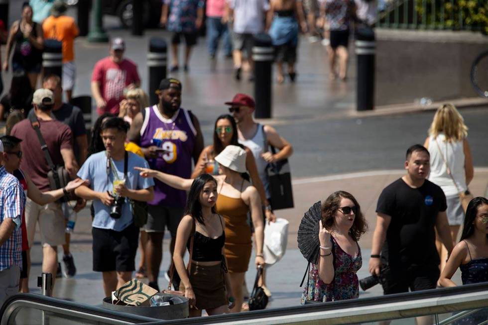 People walk on the Strip near Planet Hollywood hotel-casino in Las Vegas, Saturday, July 10, 20 ...