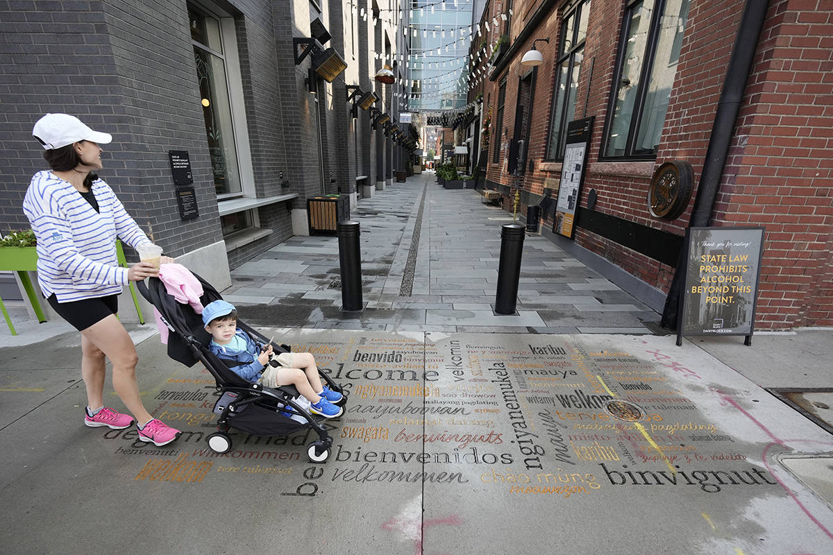 A woman pushes a stroller with a child past the entrance to the alleyway to the Dairy Block tha ...