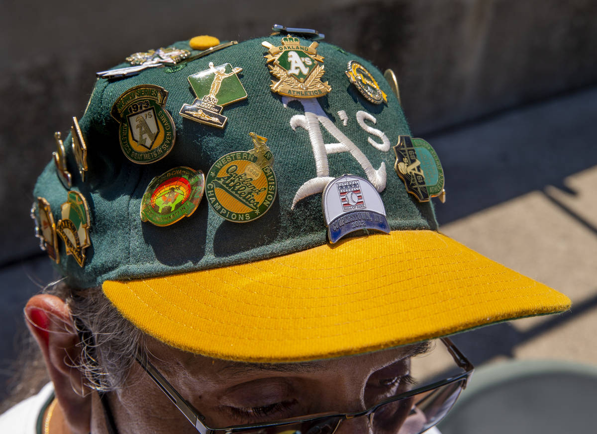 An Oakland A‘s fan sports a variety of pins on his hat as they battle the Texas Rangers at th ...