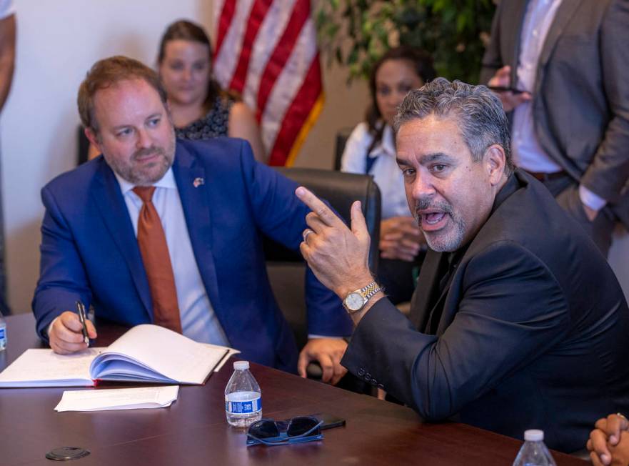 Peter Guzman with the Latin Chamber of Commerce, right, speaks beside Treasurer Zach Conine and ...