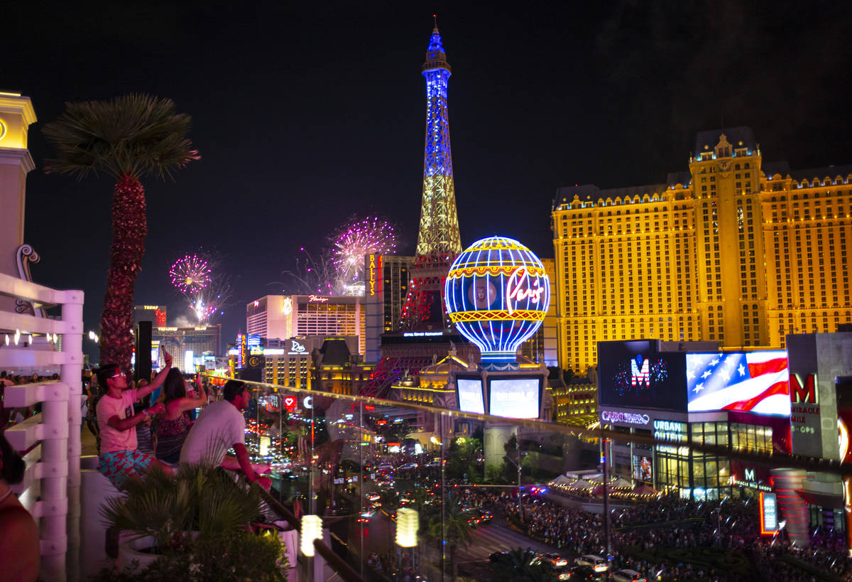 Fireworks go off along the Las Vegas Strip as people watch from the Boulevard Pool at The Cosmo ...