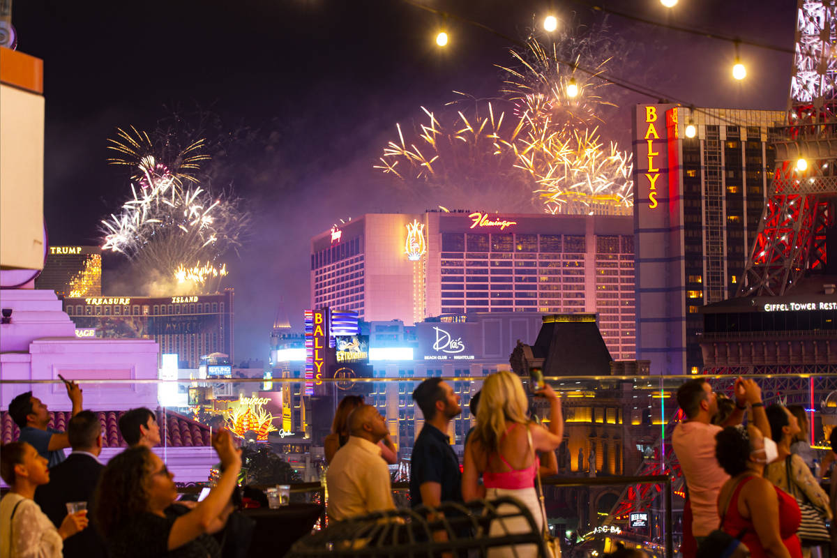 Fireworks go off along the Las Vegas Strip as people watch from the Boulevard Pool at The Cosmo ...