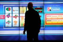A man plays a large slot machine at Seminole Casino Coconut Creek in Florida in February 2012. ...