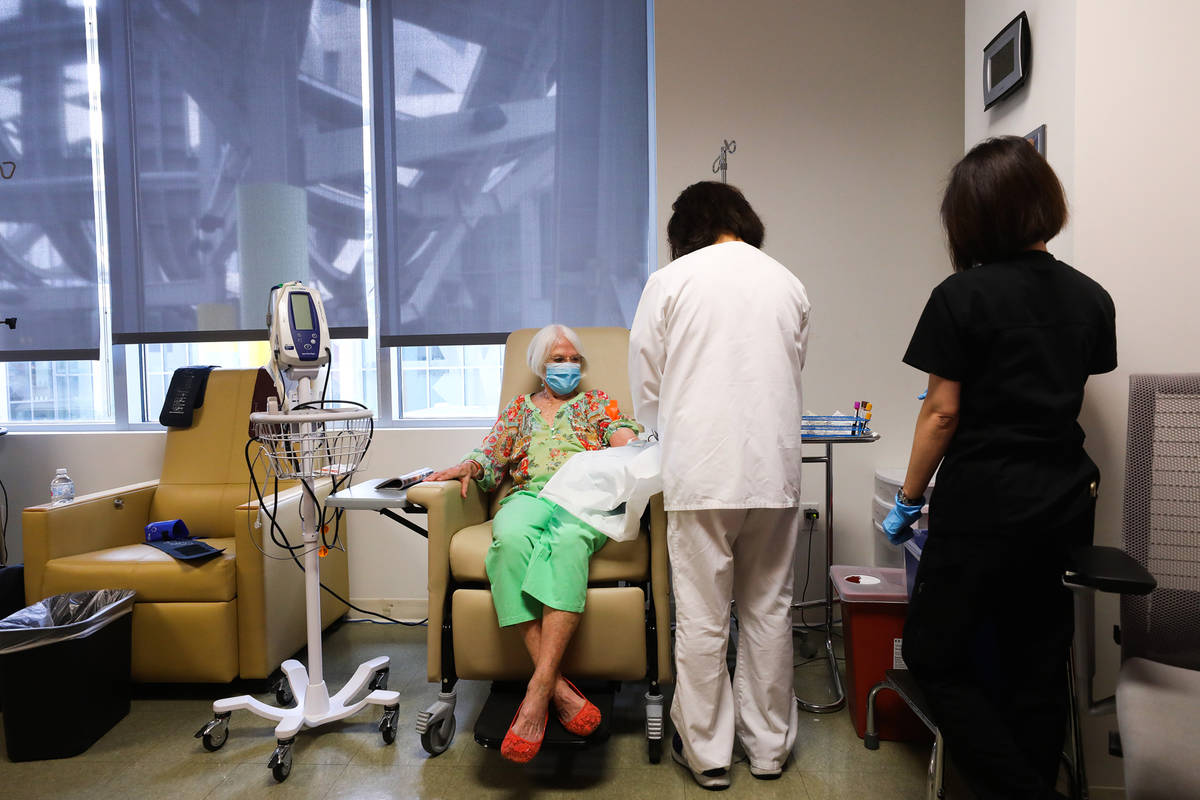 Betty Romero, a registered nurse, right, preps Judy Robinson, left, for an infusion of aducanum ...