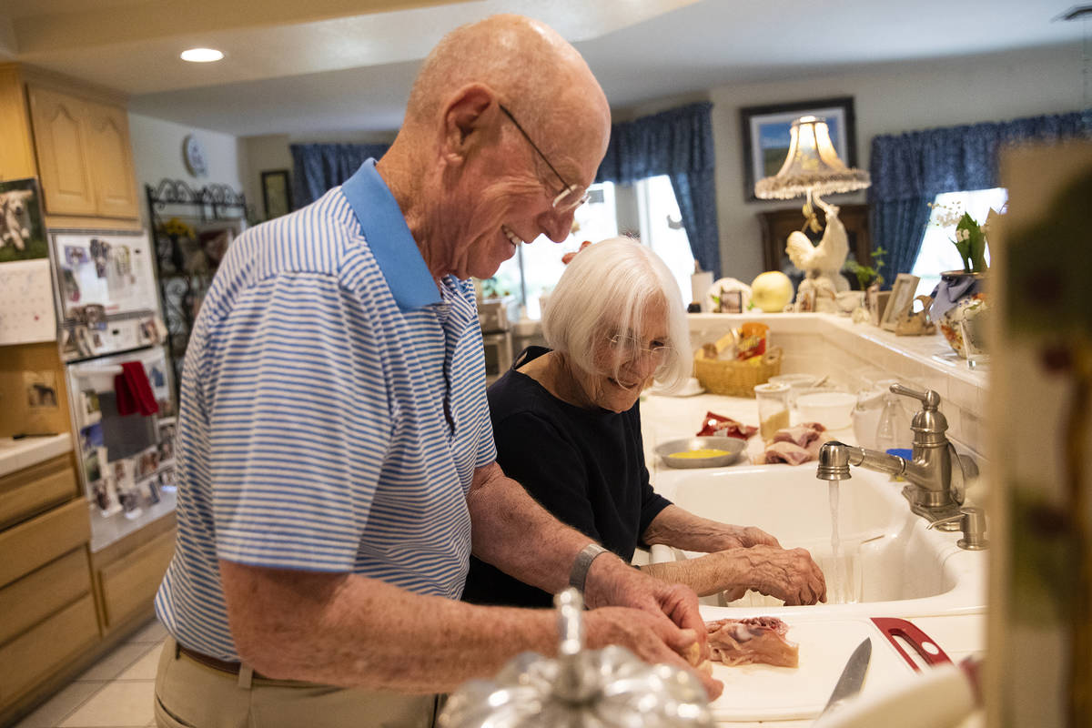 Gary Robinson helps his wife Judy Robinson cook dinner at their home in Las Vegas, Tuesday, Jun ...