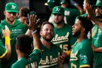 Oakland Athletics' Jed Lowrie is greeted in the dugout after hitting a solo home run against th ...