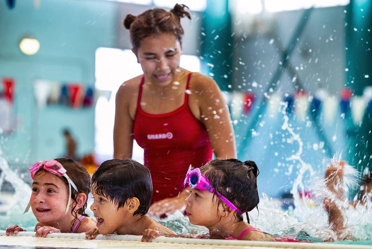 Lorelai Zimring, 5, Stefan Flores, 4, and Ariana Villeda, 4, practice their kicking for swim in ...