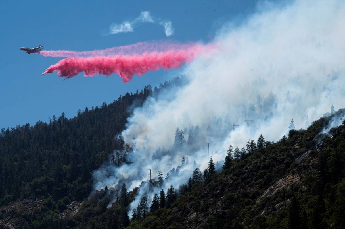 An air tanker drops fire retardant to battle the Dixie Fire in the Feather River Canyon in Plum ...