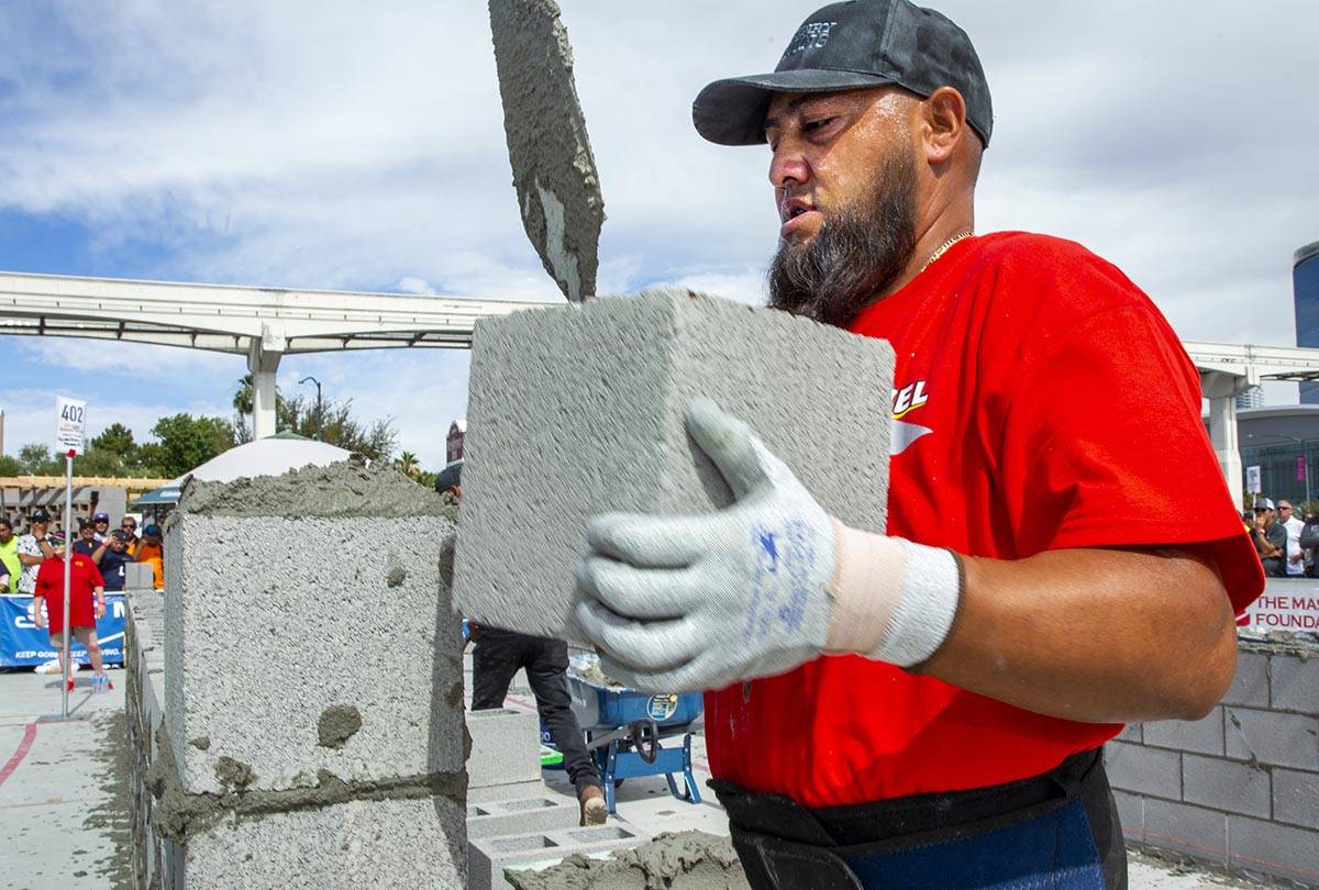 Gerardo Patlan of Phoenix, Arizona, stacks a concrete block in the Fastest Trowel on the Block ...
