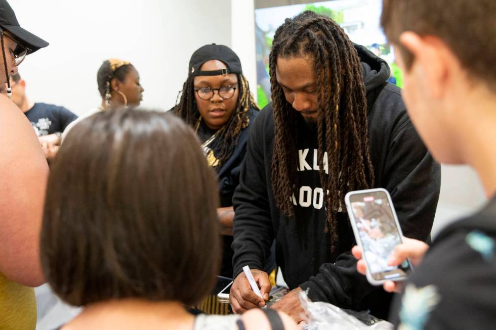 NFL running back Marshawn Lynch signs merchandise for fans and customers at the opening of his ...