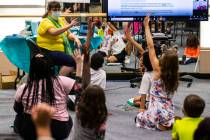 Students raise their hands as learning guide Tammy Slank, left, leads a discussion during a thi ...