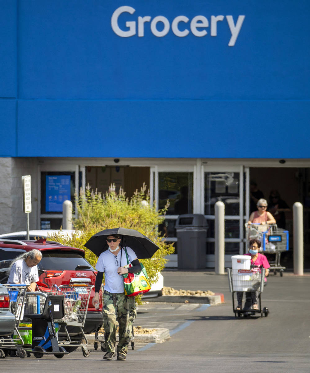 Shoppers make their way through a Walmart parking lot, most not wearing masks anymore on Friday ...