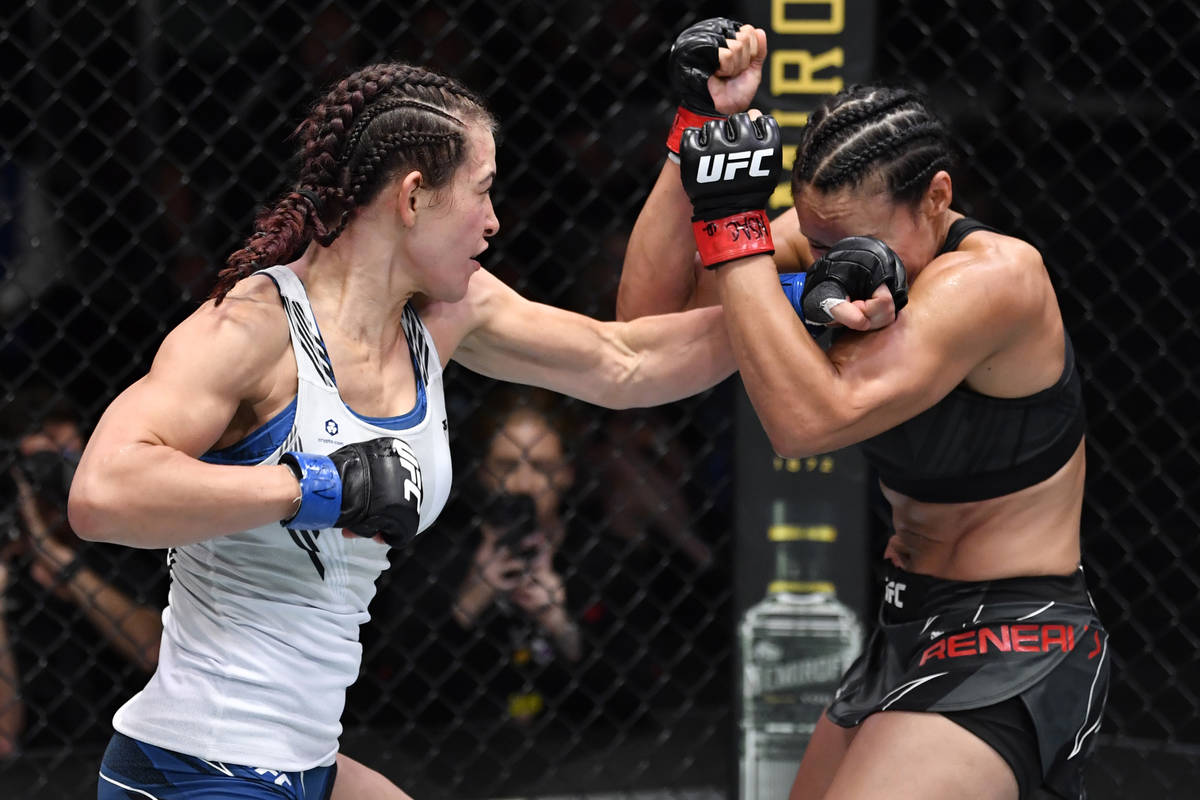 Miesha Tate punches Marion Reneau in their bantamweight bout during the UFC Fight Night event a ...