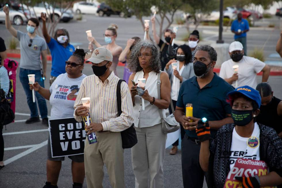 People attend a Good Trouble candlelight vigil on the anniversary of the death of civil rights ...