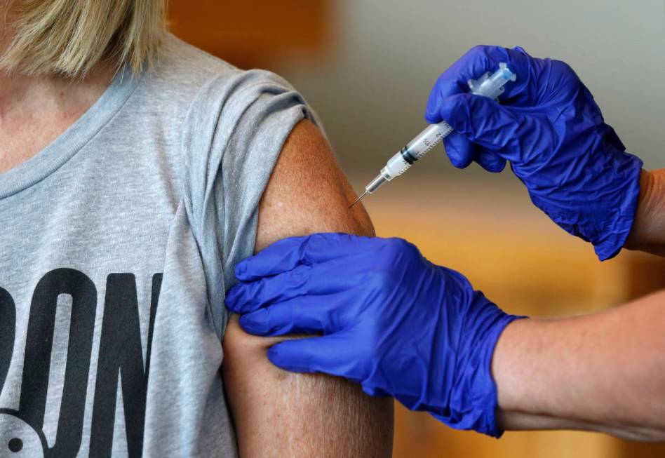 FILE - In this Monday, July 12, 2021 file photo, Karen Martin receives a COVID-19 vaccine at a ...