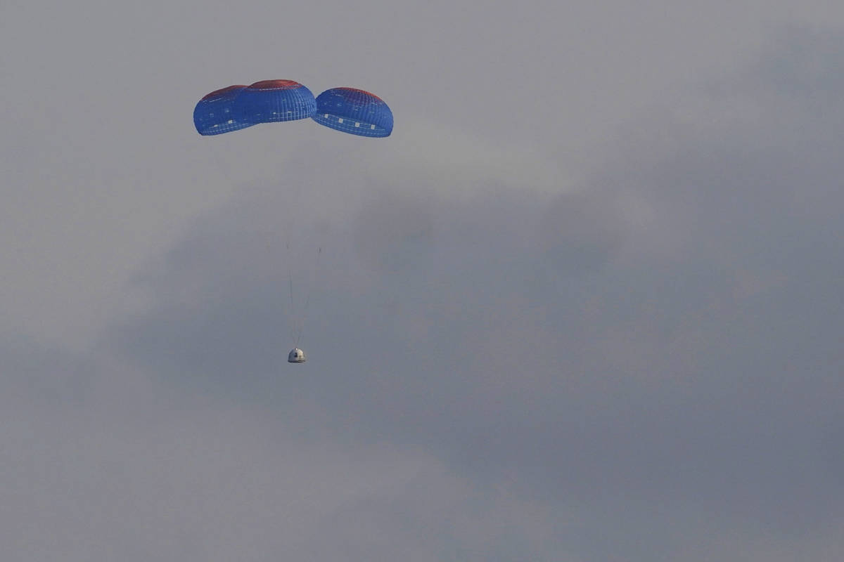 Blue Origin's New Shepard capsule parachutes safely down to the launch area with passengers Jef ...