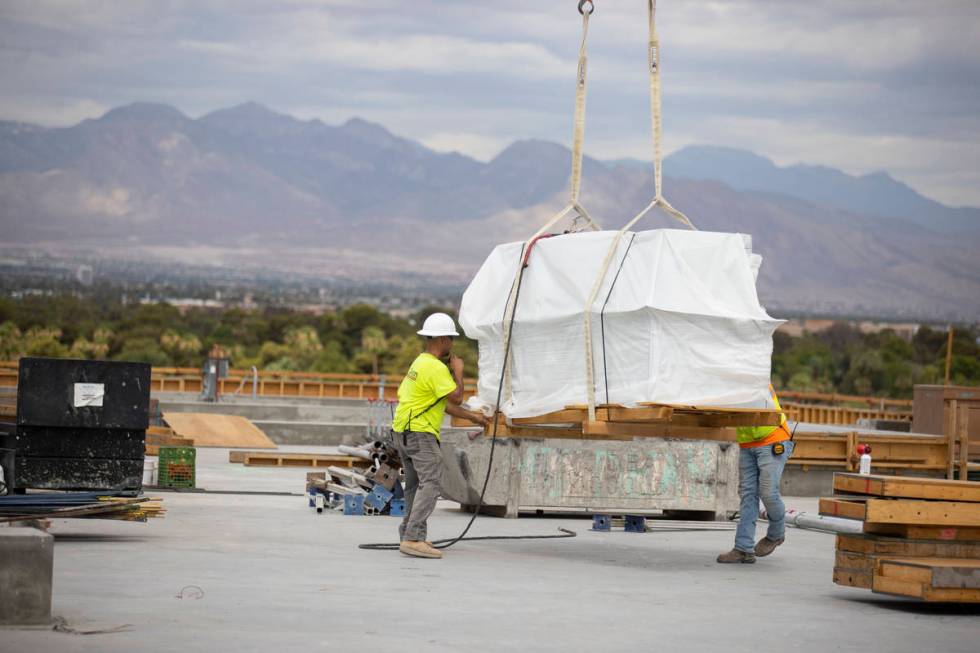 Workers move equipment on the building rooftop of the Kirk Kerkorian School of Medicine at UNLV ...