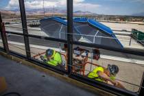Eric Oudeman, left, and Tacoma McCormick of Quantum Glass and Mirror work the exterior atop Off ...