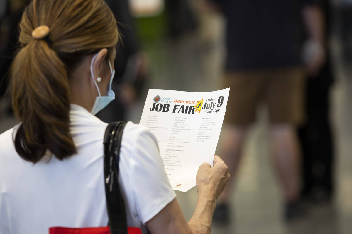 A job-seeker reviews a flyer at a summer job fair hosted by Clark County at Las Vegas Conventio ...