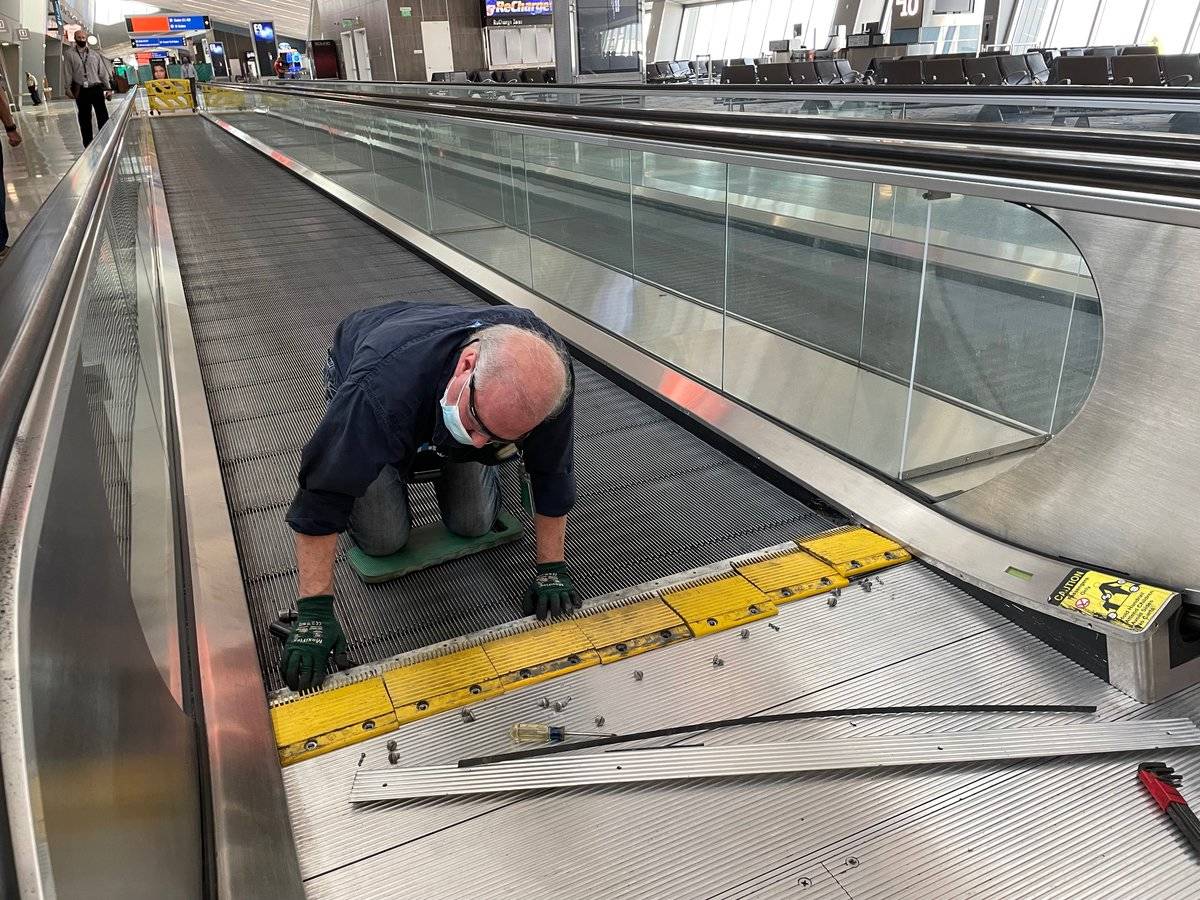 A worker preps a moving walkway at the E Gates in Terminal 3 of McCarran International Airport, ...