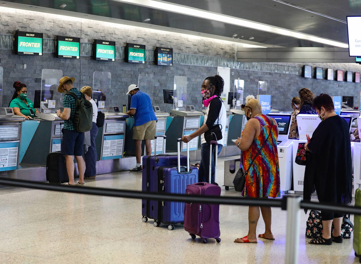 Guests check in at the Frontier counter in terminal three of McCarran International Airport in ...
